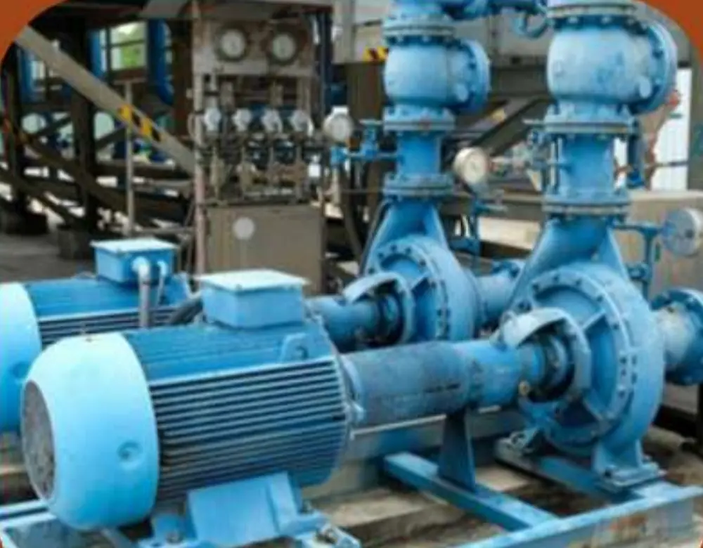 Two end-suction pump sets coupled to electric motors on a shared plinth inside a pump station, with valves and gauges above