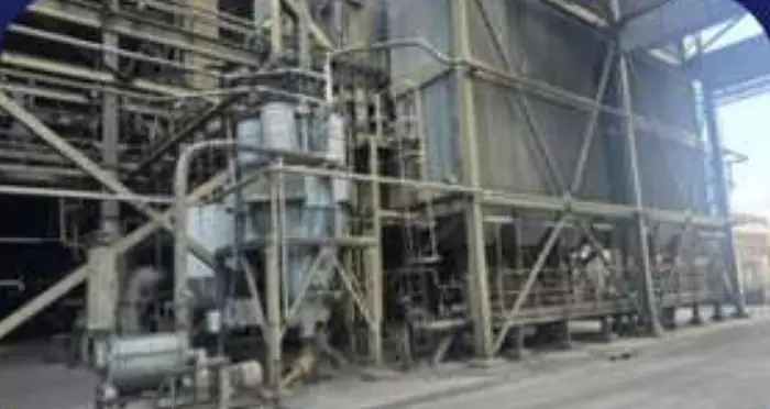 Ducting, hoppers and structural steelwork of a process plant seen from ground level